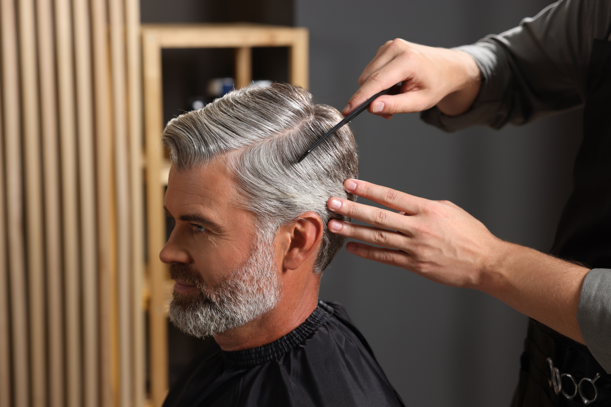 Hairdresser giving a client a precise men's classic haircut at MaryLuz Hair Salon